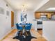 Charming dining room with a glass table, blue chairs, and chandelier lighting at 942 S Walden St # 204, Aurora, CO 80017