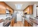 Functional kitchen featuring wood cabinetry, granite countertops, and stainless steel appliances at 942 S Walden St # 204, Aurora, CO 80017