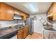 Practical kitchen featuring wood cabinetry, granite countertops, and stainless steel appliances at 942 S Walden St # 204, Aurora, CO 80017