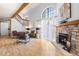 Bright living room featuring vaulted ceiling, wood floors, and stone fireplace at 942 S Walden St # 204, Aurora, CO 80017