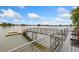 Lake view from wooden deck featuring a metal railing, bridge, and floating dock at 2017 N Fork Dr, Lafayette, CO 80026