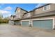 A tan two-story townhouse features multiple garages and is located in a beautiful neighborhood at 2017 N Fork Dr, Lafayette, CO 80026