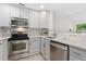 Bright kitchen featuring stainless steel appliances, white cabinets, and stylish backsplash at 2017 N Fork Dr, Lafayette, CO 80026