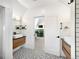 Bathroom showcasing a double vanity, geometric tiled floor, and bright lighting at 2515 Zenobia St, Denver, CO 80212