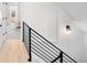 Hallway featuring hardwood floors, black metal railing and modern wall sconce at 2515 Zenobia St, Denver, CO 80212