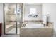 This bathroom has a tub, walk-in shower, tile accents, and natural light at 27029 E Irish Pl, Aurora, CO 80016