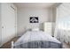 Cozy bedroom with a white-striped bed, decorative artwork, and bright natural light at 27029 E Irish Pl, Aurora, CO 80016