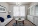 Cozy living room with white sofa, chandelier, hutch, and large window for natural light at 27029 E Irish Pl, Aurora, CO 80016