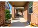 Inviting covered porch with brick pillars, flowerpots, and cozy seating at 27029 E Irish Pl, Aurora, CO 80016