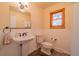 Charming bathroom featuring a pedestal sink, toilet, and window for natural light at 430 Long View Ct, Longmont, CO 80501