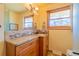 Bathroom vanity with granite countertops and backsplash, framed mirror, stylish light fixture, and a window at 430 Long View Ct, Longmont, CO 80501