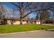 Ranch home with mature trees and a well-manicured lawn creating a welcoming curb appeal at 430 Long View Ct, Longmont, CO 80501