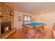 Game room with a pool table, stone fireplace, hardwood flooring, and natural light at 430 Long View Ct, Longmont, CO 80501