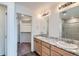 Bathroom featuring double sinks with granite countertops and a walk-in closet at 17962 E 103Rd Ave, Commerce City, CO 80022
