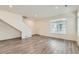 Well-lit living room with gray flooring, a staircase, and a large window, offering a modern and spacious feel at 17962 E 103Rd Ave, Commerce City, CO 80022