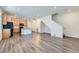 Open-concept living room featuring modern gray flooring, a staircase, and seamlessly connected kitchen at 17962 E 103Rd Ave, Commerce City, CO 80022