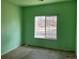 Bedroom with vibrant green walls and a large window overlooking the front yard at 10469 E Abilene St, Commerce City, CO 80022