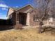 Inviting brick home showcasing a covered entry, manicured landscaping, and a welcoming ambiance at 10469 E Abilene St, Commerce City, CO 80022