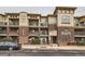 Brick building with beige siding and parking at 9481 E Mansfield Ave # 305, Aurora, CO 80014
