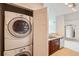 Laundry closet with a stackable washer and dryer next to the kitchen and open floor plan at 9481 E Mansfield Ave # 305, Aurora, CO 80014
