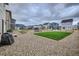 View of new homes and the backyard with a gravel ground, wooden fence, and small patch of grass at 16135 Mountain Flax Dr, Monument, CO 80132