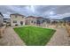 Backyard of a home with green grass, a gravel area, and a wooden fence under a cloudy sky at 16135 Mountain Flax Dr, Monument, CO 80132