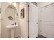 Half bath with a pedestal sink, round mirror, and neutral wall paint at 16135 Mountain Flax Dr, Monument, CO 80132