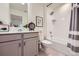 Well-lit bathroom with vanity, bathtub with shower, and gray cabinets at 16135 Mountain Flax Dr, Monument, CO 80132