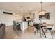 Bright kitchen with white cabinets, stainless appliances, and dining area featuring a modern chandelier at 16135 Mountain Flax Dr, Monument, CO 80132