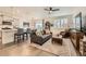 Open-concept living room featuring hardwood floors, a ceiling fan, and bright, natural light at 16135 Mountain Flax Dr, Monument, CO 80132