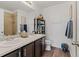 Bathroom with double sink vanity, shelving for linen, and a toilet at 27882 E 9Th Dr, Aurora, CO 80018