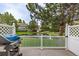 Deck overlooking community pond with grill, white lattice fence and green lawn at 13545 W 62Nd Ln, Arvada, CO 80004
