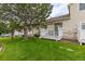 Backyard featuring green lawn, patio and siding of home with awning at 13545 W 62Nd Ln, Arvada, CO 80004
