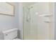 Bathroom featuring a white toilet and a glass-doored tiled shower with shelving at 13545 W 62Nd Ln, Arvada, CO 80004