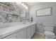 Neutral bathroom featuring decorative wallpaper, white cabinets, and open shelves at 13545 W 62Nd Ln, Arvada, CO 80004