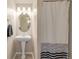 Bathroom featuring pedestal sink, large mirror and tiled shower with curtain at 13545 W 62Nd Ln, Arvada, CO 80004