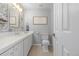 Neutral bathroom featuring decorative wallpaper, white cabinets, and white toilet at 13545 W 62Nd Ln, Arvada, CO 80004