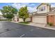 Street view showcasing well-maintained townhomes with two-car garages and mature trees at 13545 W 62Nd Ln, Arvada, CO 80004