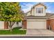 Inviting townhome with a two-car garage, brick details, and lush green lawn at 13545 W 62Nd Ln, Arvada, CO 80004