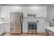 Well-equipped kitchen boasts stainless steel appliances, white cabinetry, and ample counter space for cooking at 13545 W 62Nd Ln, Arvada, CO 80004
