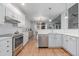 Modern kitchen features white cabinets, stainless steel appliances, subway tile backsplash, and hardwood floors at 13545 W 62Nd Ln, Arvada, CO 80004