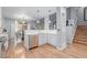 Modern kitchen with stainless steel appliances, white cabinets, and an open layout with hardwood floors at 13545 W 62Nd Ln, Arvada, CO 80004
