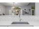 Bright kitchen showcasing sleek countertops, subway tile backsplash, modern faucet, and natural light at 13545 W 62Nd Ln, Arvada, CO 80004