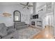 Bright living room with hardwood floors, a fireplace, and an open staircase with a modern ceiling fan at 13545 W 62Nd Ln, Arvada, CO 80004