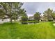 A tranquil view of homes surrounding a lush green pond, enhanced by mature trees, offering a serene living environment at 13545 W 62Nd Ln, Arvada, CO 80004