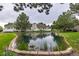 Scenic pond view with homes and white decks surrounding it, bordered by greenery, stone and mature trees at 13545 W 62Nd Ln, Arvada, CO 80004