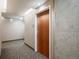 Hallway with a dark wooden door contrasted by neutral walls and grey carpet flooring at 1700 Bassett St # 609, Denver, CO 80202