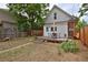 Landscaped backyard with a wooden deck featuring a table and chairs, bordered by a wood fence at 482 S Logan St, Denver, CO 80209