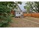 Beautiful backyard with a wood deck, table, mature trees, wood fence and access to the home at 482 S Logan St, Denver, CO 80209