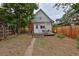 Charming backyard featuring a wood fence, a small deck with a table and chairs, and mature landscaping at 482 S Logan St, Denver, CO 80209